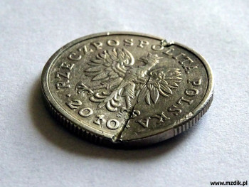 Moneta, którą ktoś usiłował przełamać na pół.
